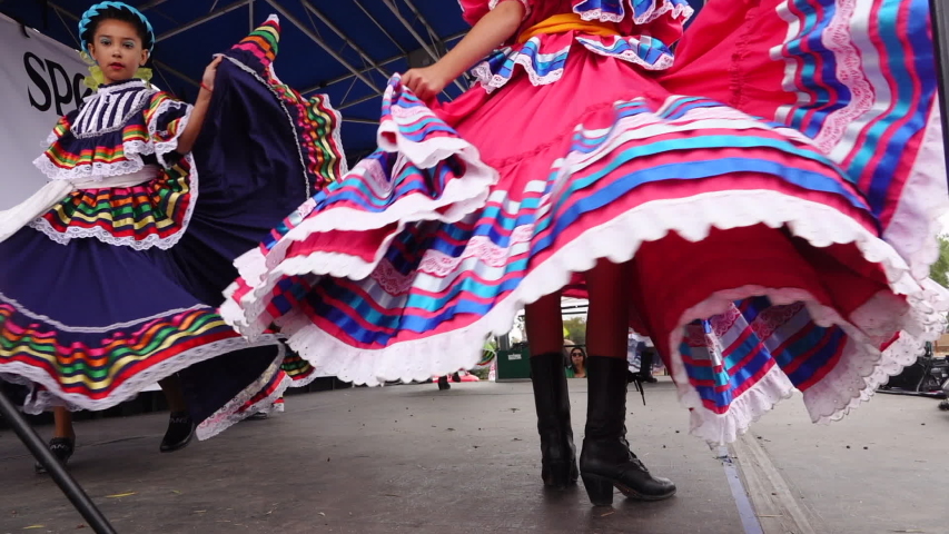 Oceanside, CA / USA - October 27, 2019: Young girls perform a traditional Mexican dance on stage, colorful skirts fly. Slo-motion clip. | Shutterstock HD Video #1039880003