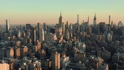 Flying backwards above Manhattan buildings, New York City at sunrise