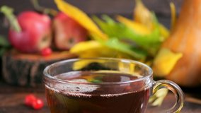 Hot tea on a wooden table against the background of the harvest (pumpkins, apples) and colorful autumn leaves. - Powered by Shutterstock - Get 15% off with code: PIKWIZARD15