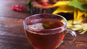 Hot tea on a wooden table against the background of the harvest (pumpkins, apples) and colorful autumn leaves. - Powered by Shutterstock - Get 15% off with code: PIKWIZARD15
