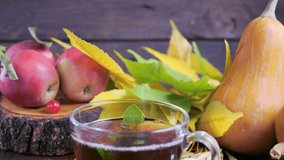 Hot tea on a wooden table against the background of the harvest (pumpkins, apples) and colorful autumn leaves. - Powered by Shutterstock - Get 15% off with code: PIKWIZARD15