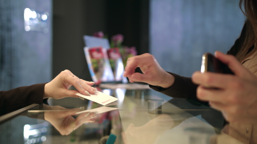 Administrator giving tourist woman key card at hotel desk. Close up of business woman hands getting room key at hotel reception. Businesswoman settling in hotel