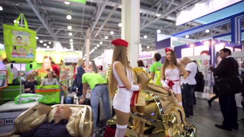 MOSCOW, RUSSIA - APRIL 17, 2015: Women present a massage chair during international exhibition of professional cosmetics and equipment for beauty salons, Intercharm.
