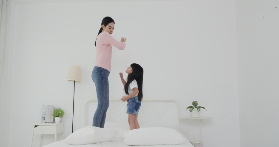 Mother and her daughter dancing together with happy emotion at bedroom. lifestyle concept. | Shutterstock HD Video #1039910024