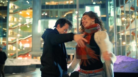 Happy young couple dancing latin dance together in night winter city street.  Slow motion, 4K UHD	