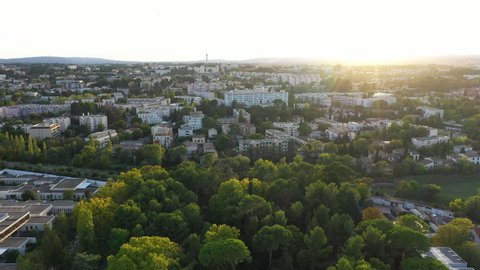 Buildings residential area Montpellier Saint Eloi aerial shot sunset over trees and houses France