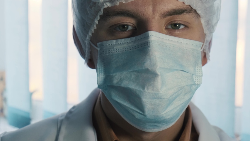 Portrait of a handsome smiling doctor removing face mask, close up Royalty-Free Stock Footage #1039927487