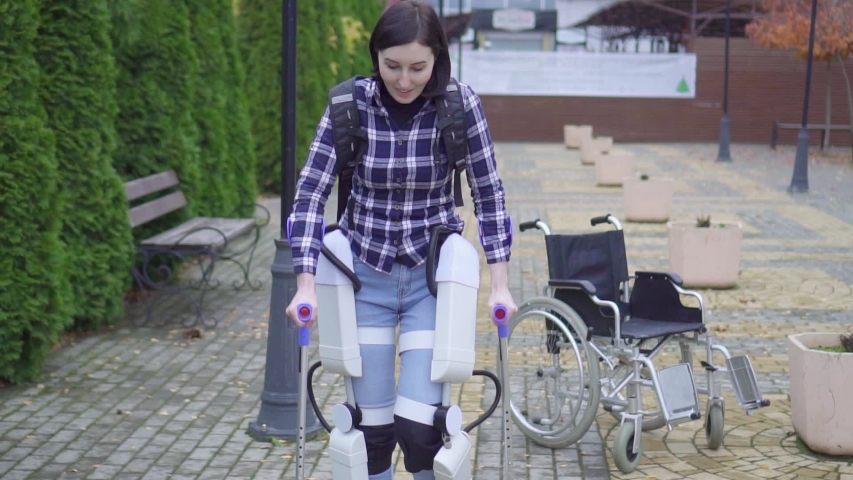 beautiful young paralyzed disabled woman is learning to walk again with the help of an exoskeleton