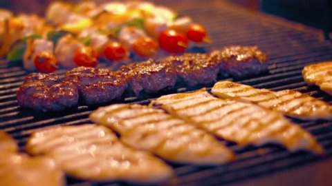 FullHD video - Local. Turkish street vendor cooks kabobs. hamburgers and chicken breasts on a barbecue grill in preparation for the after work crowd.