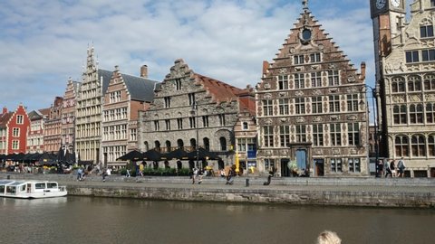 Ghent, Flanders region, Belgium. August 2019. The charming old town seen from the bridge of St Michael. View of the canal with the splendid buildings overlooking the water. Pan movement,tourists 25fps