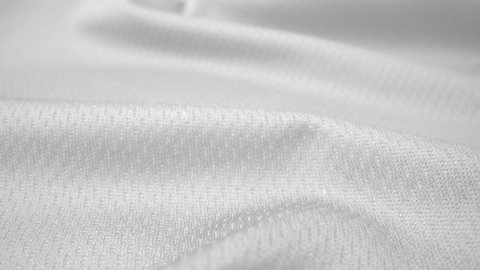Close up detailed cloth texture of shiny spandex lycra cloth flowing with dolly shot in macro close-up view. Wavy clean elastic weave material. Textile abstract background. Clothing industry concept.