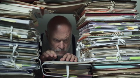 Busy office clerk working behind a wall of paperwork, he is sending a man to another office, bureaucracy and administrative process concept