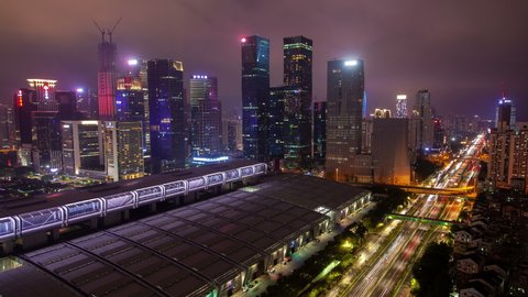 Timelapse Futian district with famous Shenzhen Convention Exhibition Center roof near illuminated highway under pink sky at night
