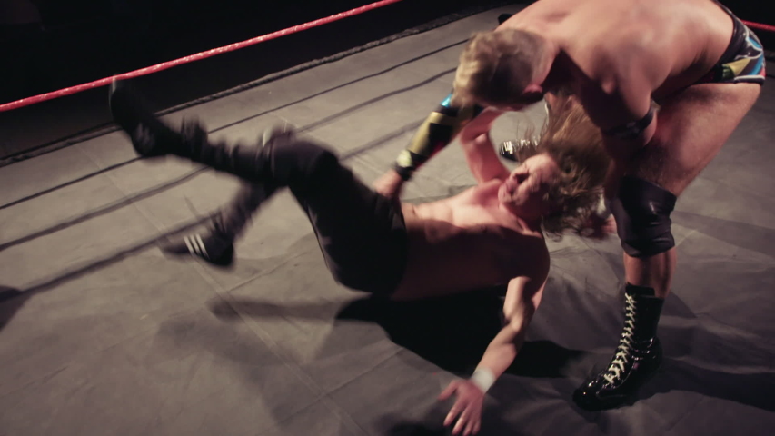 Pro wrestler slams his opponent in the ring & backflips onto him, wrestling match footage | Shutterstock HD Video #1039960184