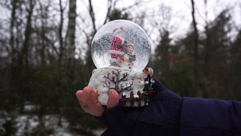 Someones hand holding traditional austrian festive snowball against winter background