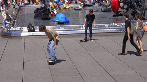 Paris, France - June 2019 : Two young boys skateboarding in front of the Stravinsky Fountain at the center of the Stravinsky Square near the Centre Pompidou Beaubourg in the center of Paris France