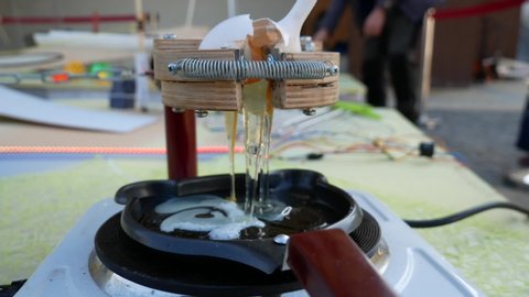 
Rube Goldberg Machine. A broken egg flows into a heated pan.