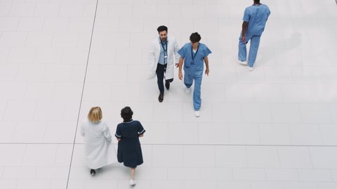 Overhead View Of Medical Staff Walking Through Lobby Of Modern Hospital Building