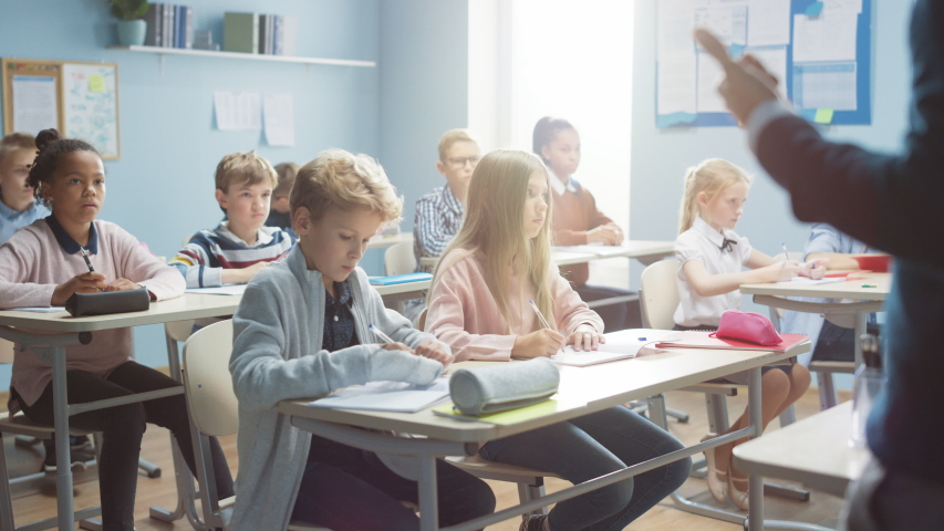 Elementary Classroom of Diverse Bright Children Listening to the Teacher Giving a Lesson. Everyone Raises Hand Knowing the Right Answer. Brilliant Kids in School Learning Science, Creative Thinking | Shutterstock HD Video #1039966958