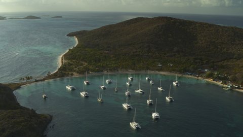 Aerial view approaching catamaran boats in bay near island / Salt Whistle Bay, Mayreau, St. Vincent and the Grenadines