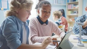 In the Elementary School: Class of Smart Young Children Work as a Team Using Tablet Computers to Program Wind Turbines. Classroom with Kids Learning about Eco-Friendly Forms of Renewable Energy - Powered by Shutterstock - Get 15% off with code: PIKWIZARD15