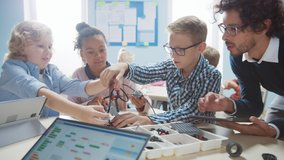 Elementary School Robotics Classroom: Diverse Group of Brilliant Children with Enthusiastic Teacher Building and Programming Robot. Kids Learning Software Design and Creative Robotics Engineering - Powered by Shutterstock - Get 15% off with code: PIKWIZARD15