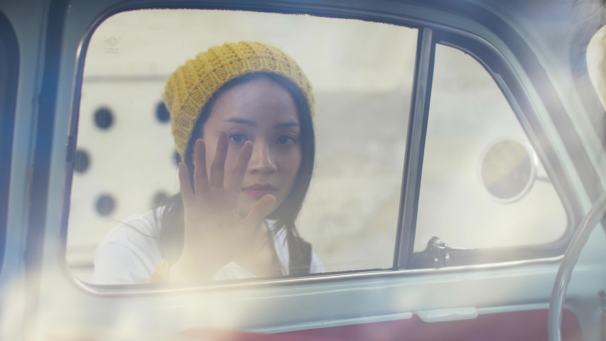 Portrait of a woman looking inside of a vintage car