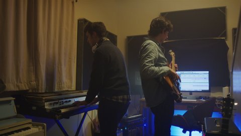 Men playing bass guitar and keyboard in music studio / Provo, Utah, United States