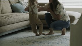 Mother crouching and dancing with daughter in living room / American Fork, Utah, United States