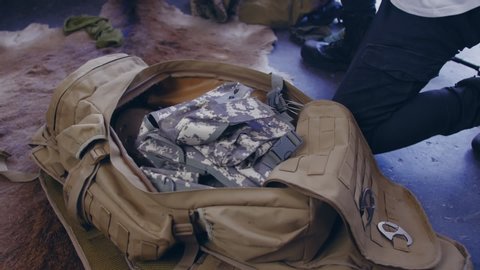 A soldier collects a bag of military clothing for service. Military soldier backpacks. close up shot.