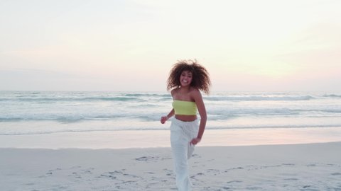 African american woman very happy on the beach. She is smiling and dancing. Premium Cinematic 4K.