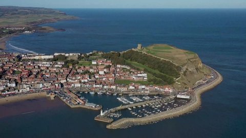 Aerial footage of the beautiful seaside coastal town of Scarborough in the North Yorkshire area of the UK England, showing the beach, harbour and 12th-century historic old Scarborough Castle