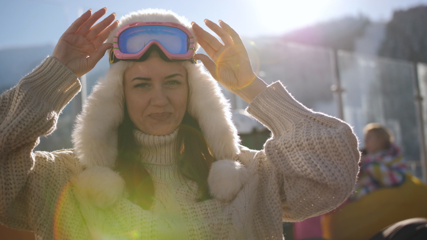 Happy woman in ski resort sitting in the outdoor cafes and enjoy the rest in the rays of the setting sun.