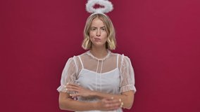 Upset angel woman in carnival costume show her emotions isolated over red wall background