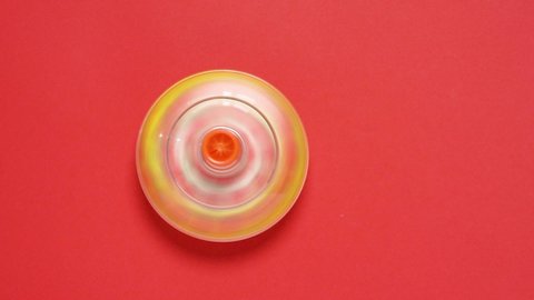 Colorful spinning top toy on red background