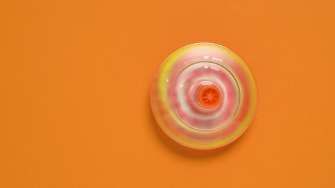 Kids whirligig humming spinner on orange background