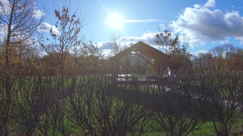 Wooden gazebo for relaxing in a city park on the banks of a pond