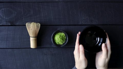 Woman put whisk and matcha tea on the table
