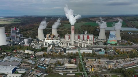 Aerial view of huge coal thermal power plant, steaming chimney and cooling towers - industrial landscape panorama of Europe from above