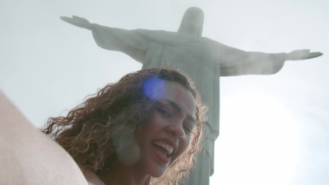 Rio de Janeiro, Rio de Janeiro / Brazil - Circa October 2019: Tourist girl in Rio de Janeiro showing Christ the Redeemer, making selfie photos or streaming video.