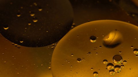 Oil drops on a water surface abstract background. Abstract colorful background. Foam of Soap with Bubbles macro shot. Closeup bubbles in water. Golden yellow bubble.Yellow water bubbles wallpaper