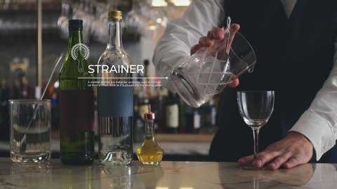 How to make a Martini Part 6 of 7: A bar man strains and pours the mixed drink into a glass in a fancy bar. 4K RED with motion graphics.  