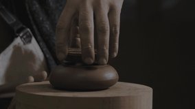 craftsman tries on a lid on a teapot made of clay Yixing. Handmade clay teapot for the Chinese tea ceremony. brown pottery teapot. 4k video. 59.94 fps