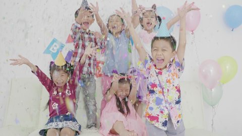 Group of asian children enjoy with throwing confetti in party,slow motion.