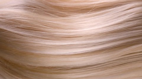 Hair. Beautiful healthy long straight blonde hair close-up texture. Dyed Wavy white blond hair background, coloring, extensions, cure, treatment concept. Haircare. Slow motion 4K UHD video