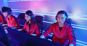 Team of asian teenage cyber sport gamers play in multiplayer PC video game on eSport tournament