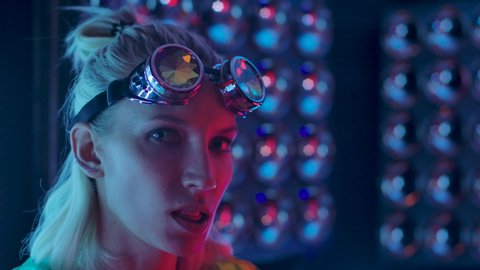 Cute Lady Blowing Bubble Gum. Portrait of Young Sexy Playful Blond Girl Standing in Clubbing Dressed Wear in Pink Blue Rays Light and Chewing Candy. 30s Woman Looking at Camera Closeup. 4k Slow Motion