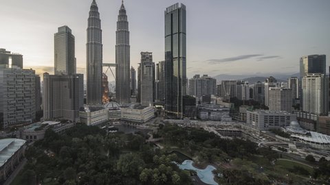 Kuala Lumpur, Malaysia - August 31, 2019: 4k time lapse of day to night to day (from sunset to sunrise) at Kuala Lumpur capital city centre, featuring the landmark Petronas Twin Towers. Tilt up