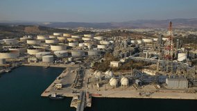 Aerial drone video of industrial oil and gas refinery in Mediterranean bay