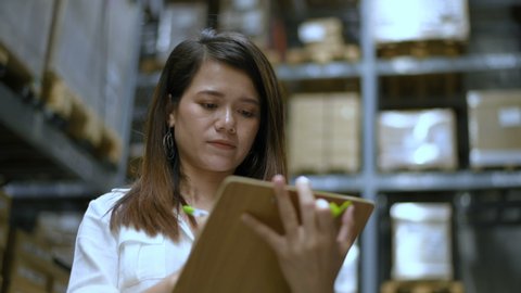 Business concepts. The girl is checking the balance of goods in the stock room. 4k Resolution.